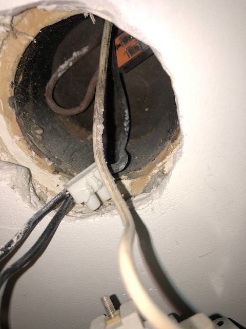 Elektriska kablar och rörinstallation synlig i väggöppning med ojämna kanter.