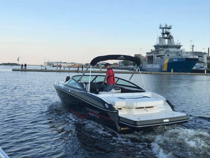 Monterey 214 Supersport Bowrider med namnet Black Diamond seglar på vatten nära kustbevakningsfartyg.