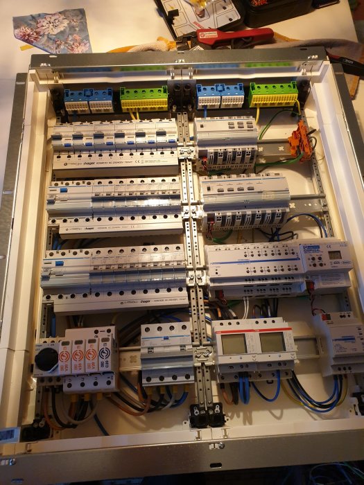 Öppen elcentral med ordnat montage av säkringar och elektriska komponenter på ett bord.