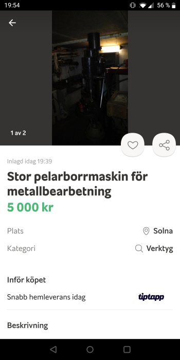 Stor pelarborrmaskin i dunkelt upplyst källare undersöks med ficklampa.