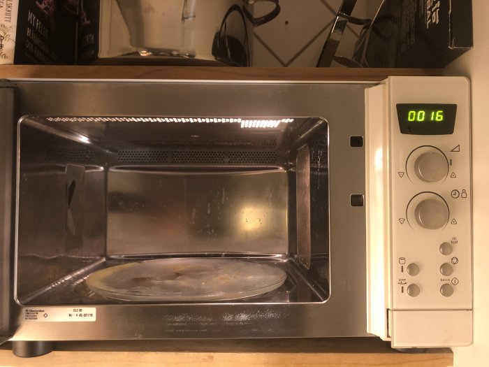 Electrolux mikrovågsugn med öppen dörr, insida och display visar 00:16.