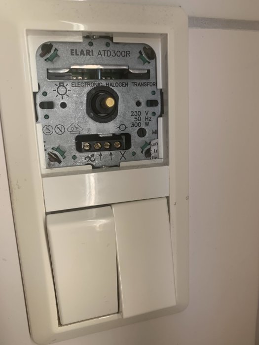 Söndrig dimmer ELARI ATD300R utan frontpanel, exponerade inställningsknappar och skruvanslutningar.