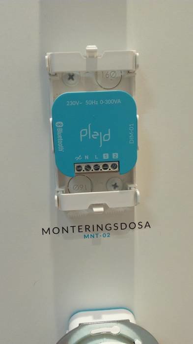 Monteringsdosa med elektronisk enhet, dragavlastning för kablar och fästen för rör.