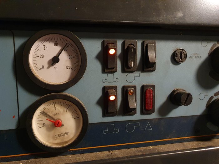 Två mätinstrument på pannans kontrollpanel, temperaturmätare visar ca 80°C och tryckmätare cirka 1 bar.