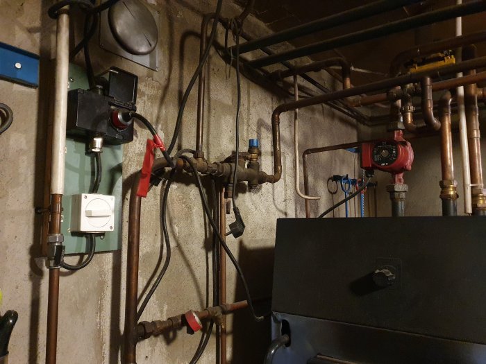 Installation av värmesystem med kopparledningar, cirkulationspump och olika ventiler.