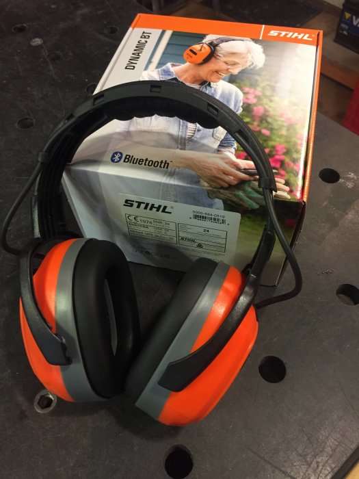 Stihl hörselskydd med Bluetooth på en verktygsbänk framför produktförpackning.