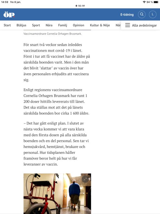 En person från personalen på ett äldreboende går i en korridor med en städvagn.