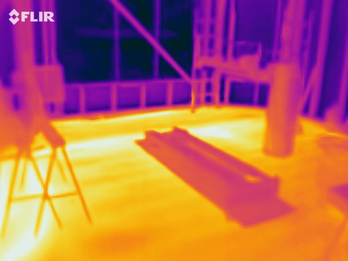 Termisk värmekamerabild som visar värmeutstrålning i ett rum under konstruktion.