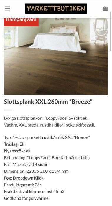 Mörk parkett av typen Slottsplank XXL Breeze i rökt ek installerad i ett sovrum med vit säng och spegel.