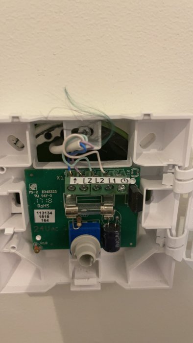 Öppet eluttag med synlig kretskort och anslutna trådar under installation eller reparation.