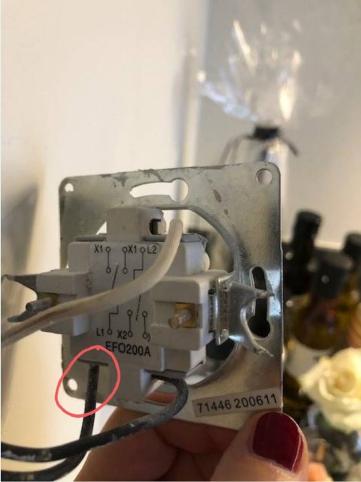 Närgräns av en elektrisk installation med en markerad röd kabel som behöver avlägsnas från en anslutningsdosa.
