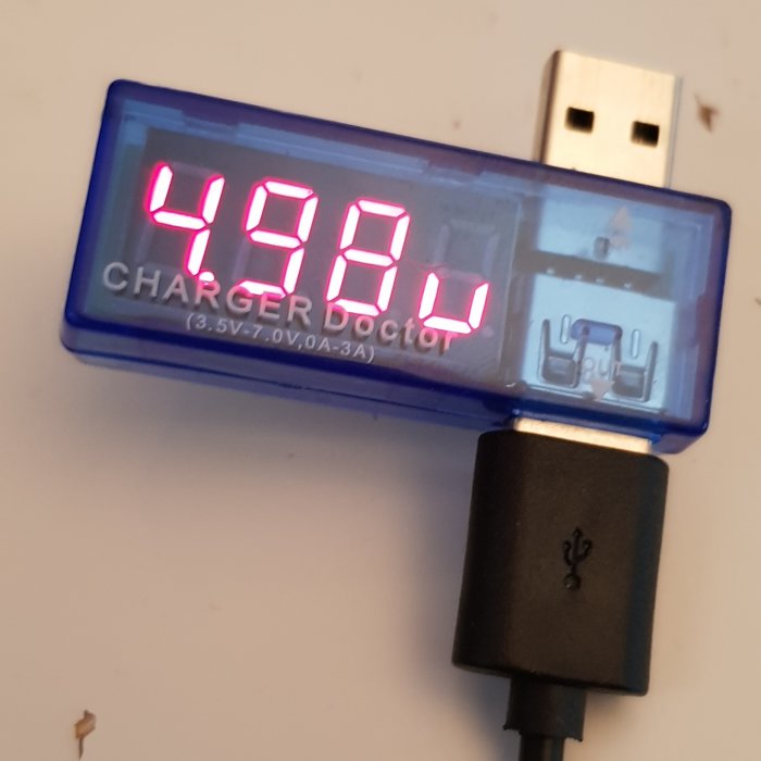 USB-multimeter visar 4.94V på digital skärm med texten "CHARGER Doctor" och ansluten USB-kabel.