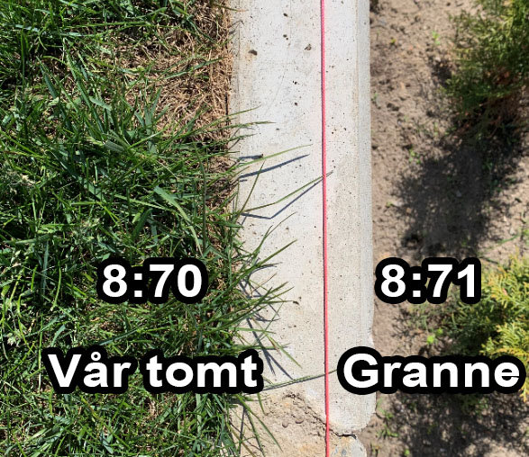 Vy ovanifrån på gränsen mellan två tomter, markerad med en röd linje, visande stödmur och gräs på ena sidan och jord på den andra.