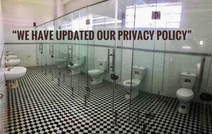 Badrum med genomskinliga toalettavskärmningar och texten "We have updated our privacy policy" på väggen.