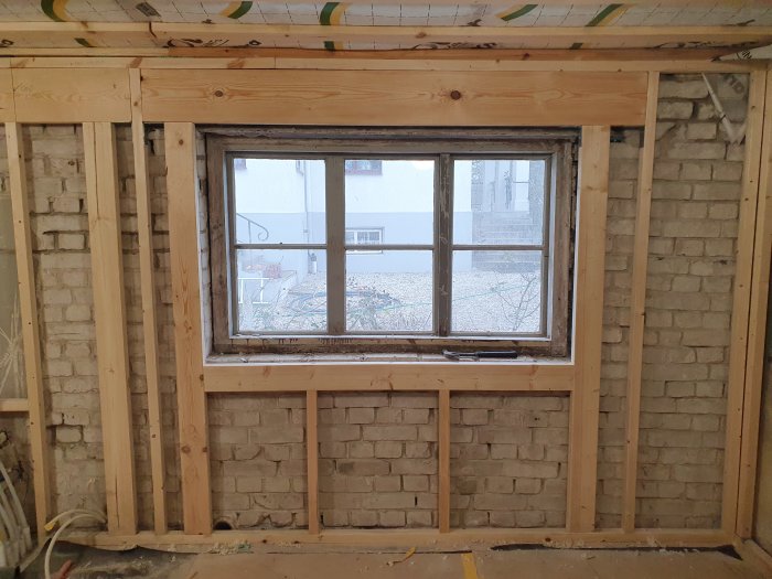 Nyinstallerat fönster i en tegel- och trästomme under en innebordsrenovering.