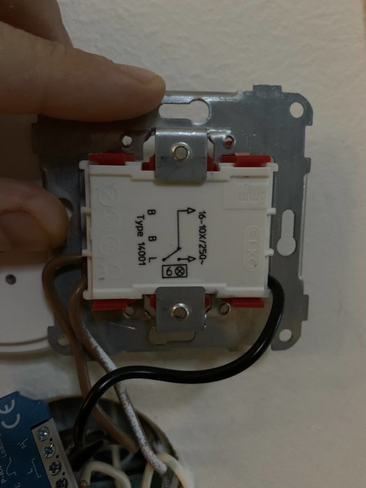 Eluttag som installeras på vägg, med öppet fram visande anslutna kablar och schematisk teckning på uttaget.