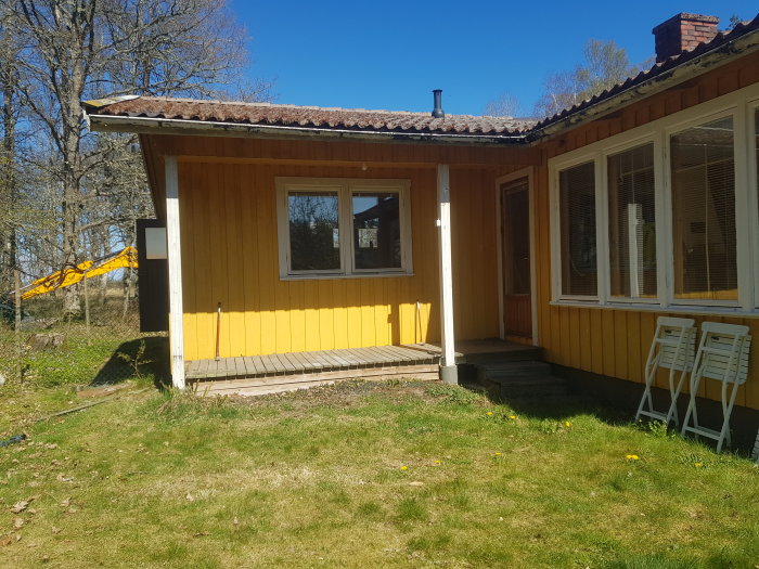 Liten gul veranda vid trähus, redo för rivning inför utbyggnad.