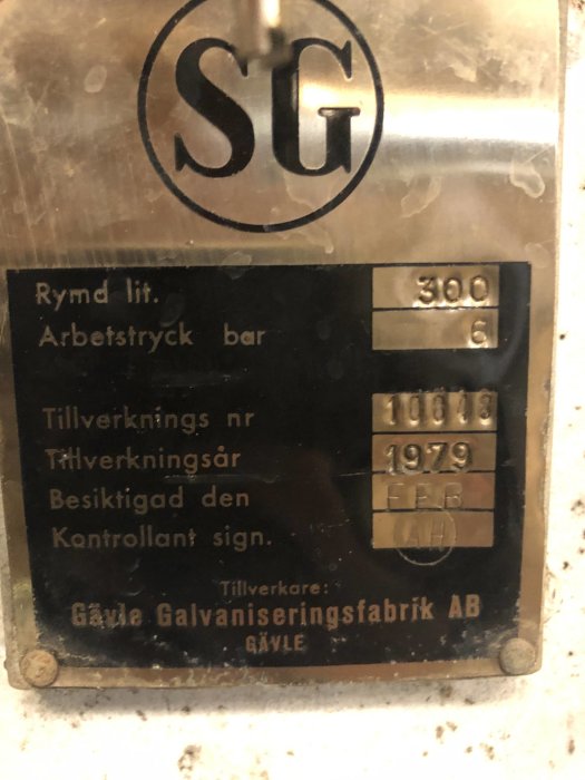 Metallskylt med texten "SG", teknisk data och tillverkarens namn "Gävle Galvaniseringsfabrik AB".