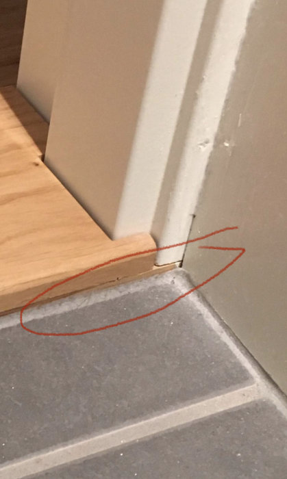 Blindtröskel i trä som är 3-4 mm för hög vid dörröppning med markerad höjdskillnad.
