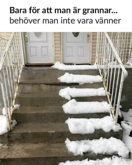 Dubbla dörrar till hus med halvskottad trappa, ena sidan rensad från snö, den andra täckt.