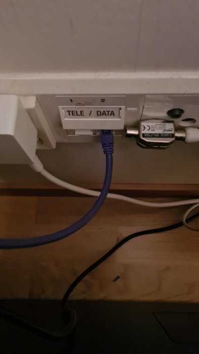 Tele- och datavägguttag med en inkopplad nätverkskabel och en TV-kabel.