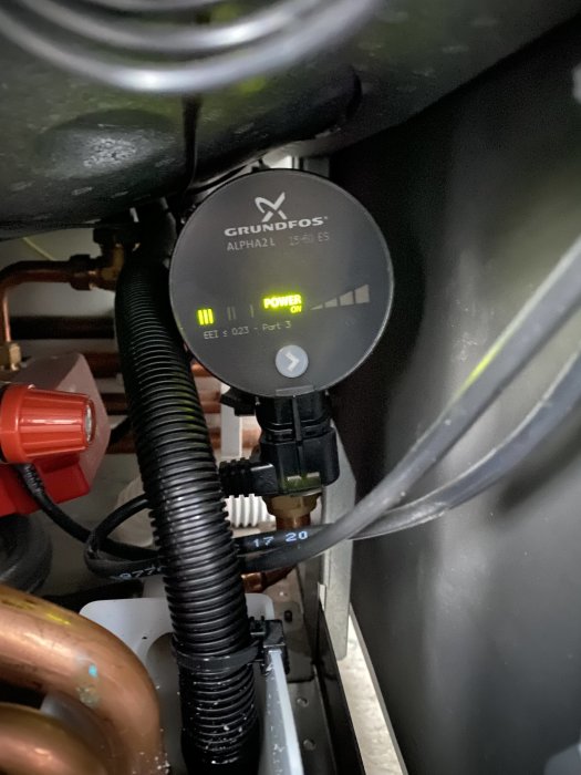 Grundfos cirkulationspump installerad i ett värmesystem, indikatorn visar att pumpen är igång.