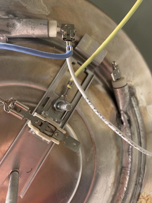 Elektriska kablar monterade i klämfästen inuti en apparatdosa.