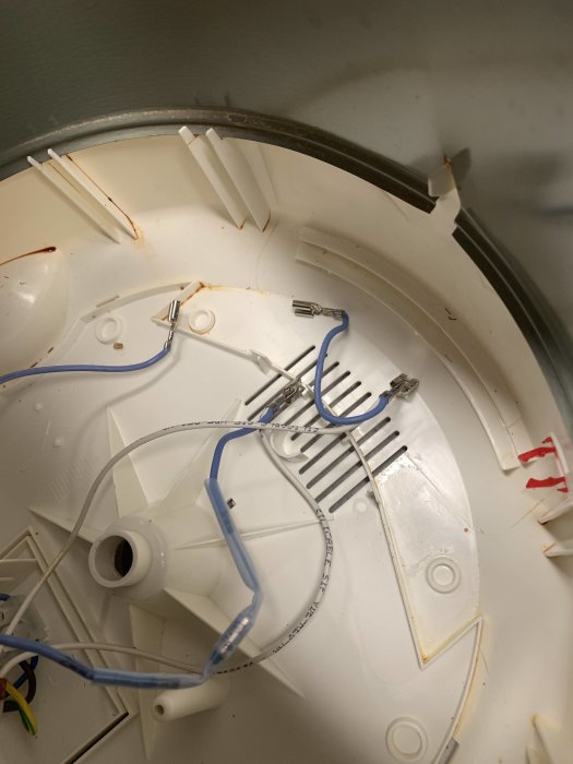 Interiör av en demonterad rökdetektor med synliga ledningar och komponenter.