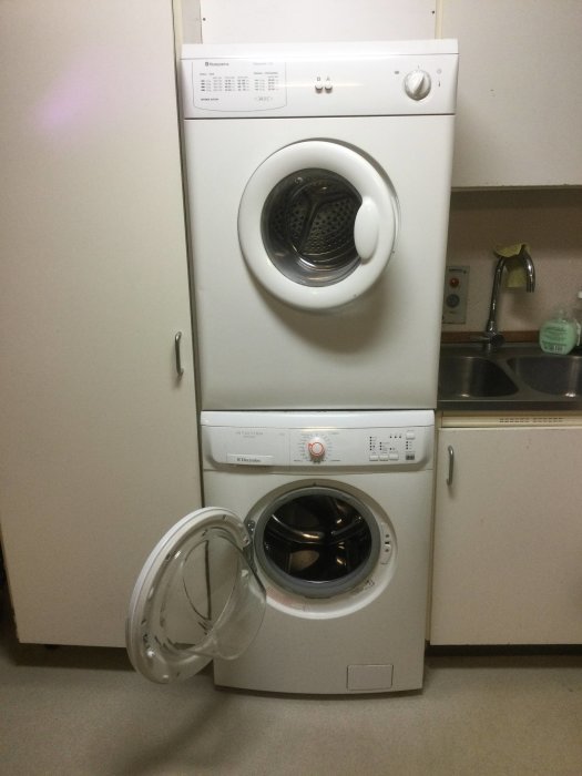 Öppen tvättmaskin i ett kök bredvid en stängd och bredvid diskbänk, storlek 60x80x60 cm.