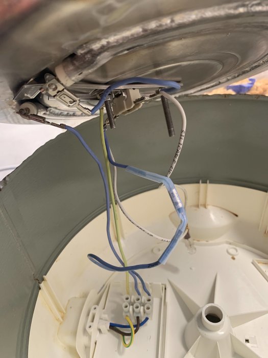 Kabelanslutningar i taklampa med en lång blå kabel kopplad till termostat och en kort blå kabel.