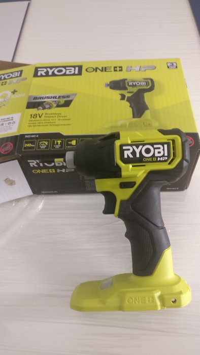 Ny Ryobi ONE+ HP slagskruvdragare står framför sin förpackning på en vit bänk.