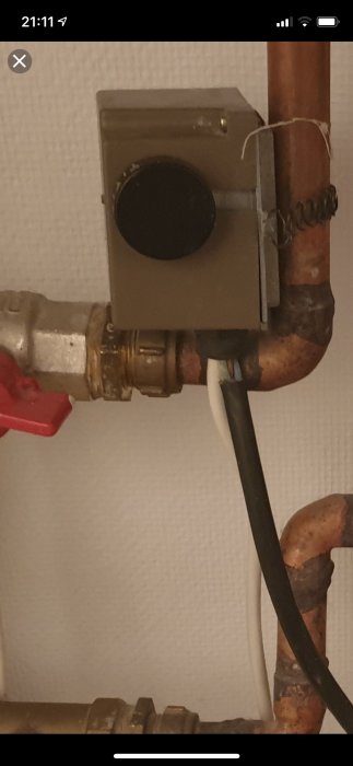 Otydlig dragavlastning på en apparat med synlig innersladd, intill vattenrör.