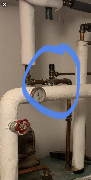 VVS-installation med rör och manometer markerad med en blå cirkel.