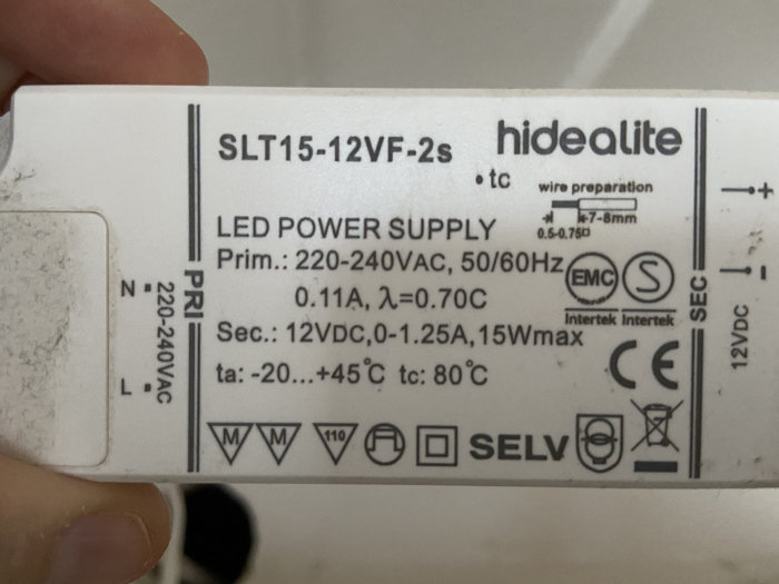Närbild av en LED-transformator från Hidealite med tekniska specifikationer, använd i ett köksbelysningsproblem.