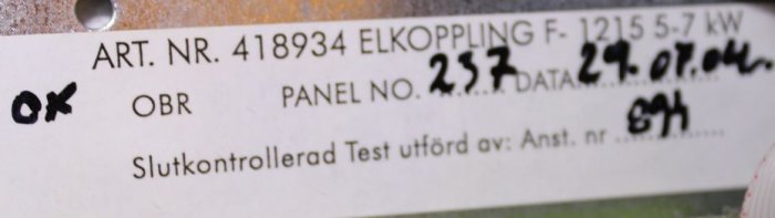 Skylt med artikelnummer och specifikationer för elkoppling, 5.7 kW, kontrollinformation och datum.