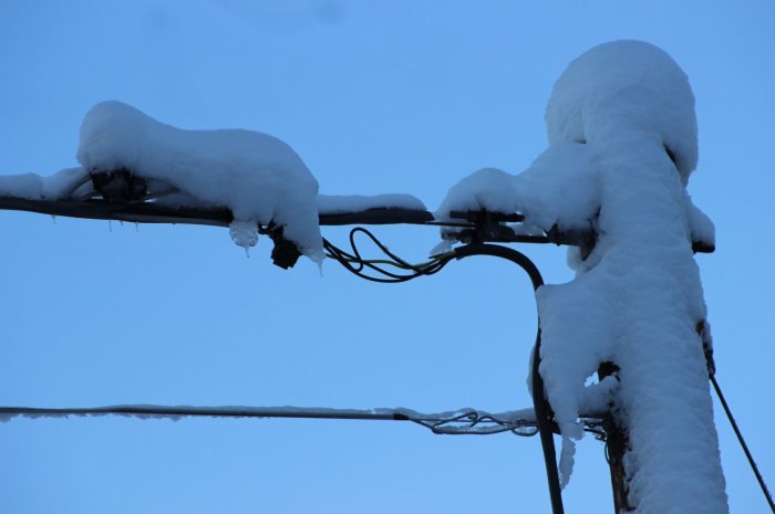 Elledningar täckta av snö med osäkerhet om det är den sökta skylten angående 5-7 kW.