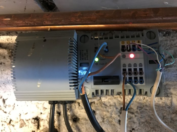 Styrbox för vattenburen golvvärme med LED-indikatorer och flera anslutna kablar.