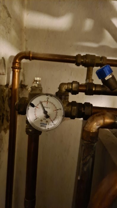 Manometer på 1,5 bar installerad på rörsystem, inga synliga luftbubblor.