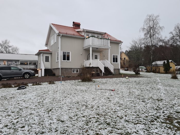 Altanbygge planering, hus fasad med ytterdörr och mark på snötäckt tomt.