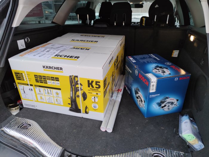 Kärcher högtryckstvätt och Bosch cirkelsåg i nya förpackningar i bagageutrymmet på bil.