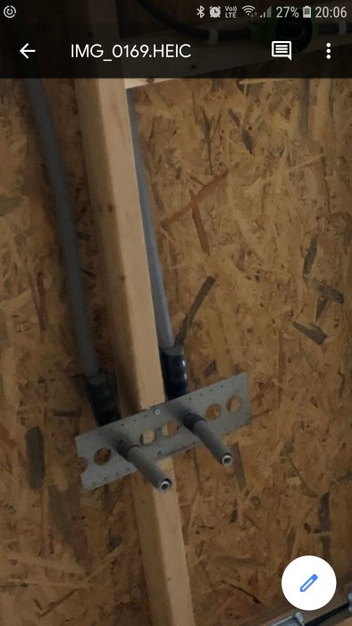 Rörinstallationer för vatten som utgår ur en OSB-vägg med fixeringskonsoler.