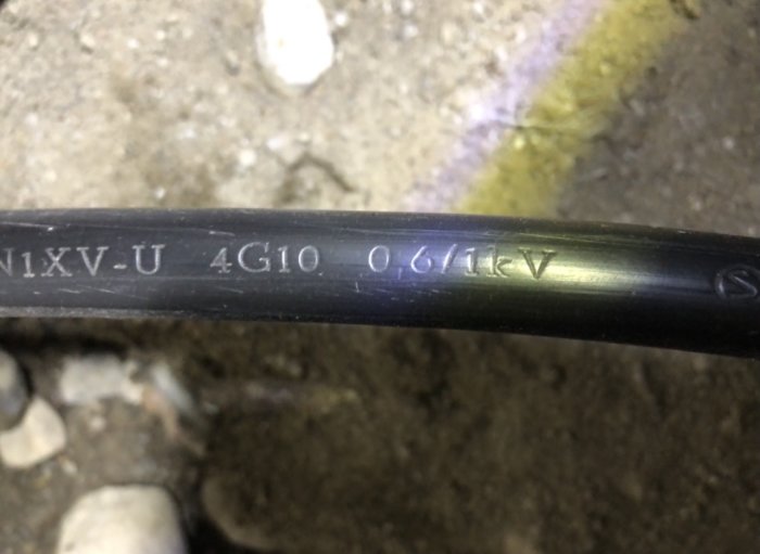 Närbild på en elektrisk kabel märkt med "N1XV-U 4G10 0,6/1kV".