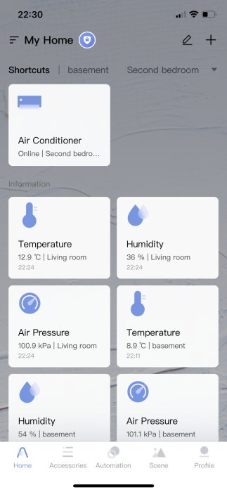 Smart hem-skärm som visar temperatur, luftfuktighet och lufttryck i ett vardagsrum och en källare.