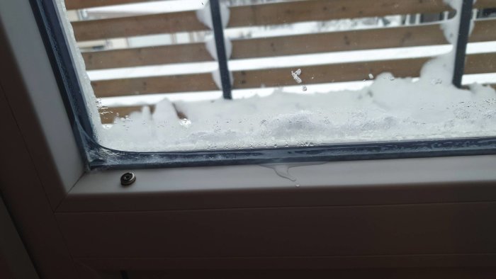Fukt och kondens på insidan av ett fönster med synlig is och droppar.
