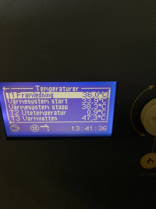 Blå bakgrundsbelyst display som visar temperaturinställningar för ett värmesystem.