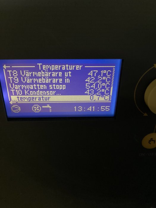 Digital display av värmesystem visar olika temperaturvärden, inklusive "Värmebärare ut" och "Kondensor temperatur".