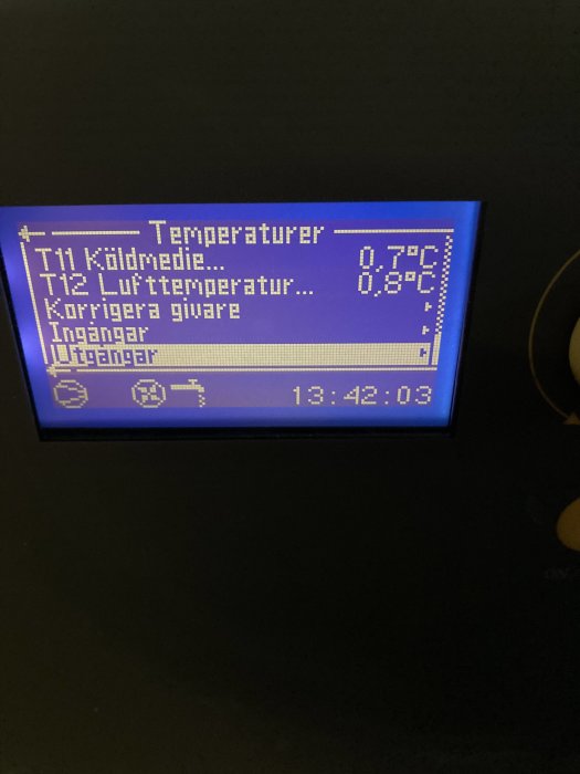 Digital display som visar temperaturmätningar inomhus, T11 0.7°C och T12 0.8°C, med klockslag 13:42:03.