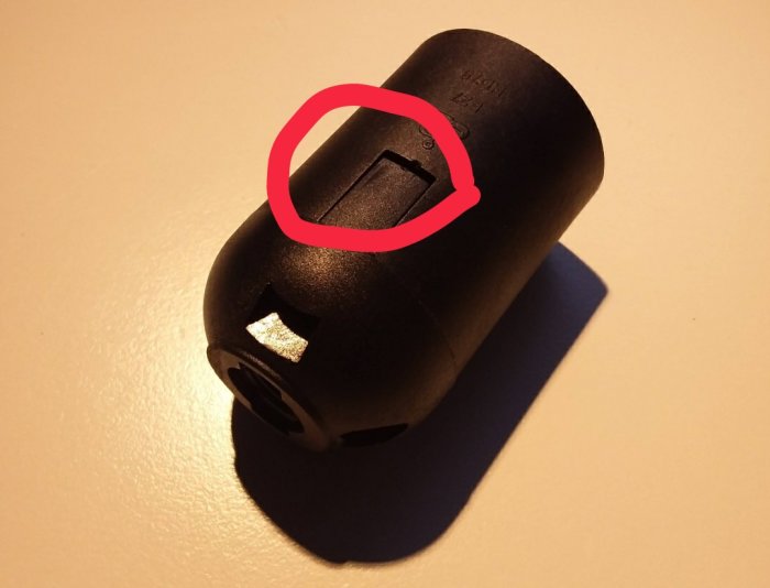 Närbild på en svart mekanisk komponent med märkt spår för insättning av mejslar.