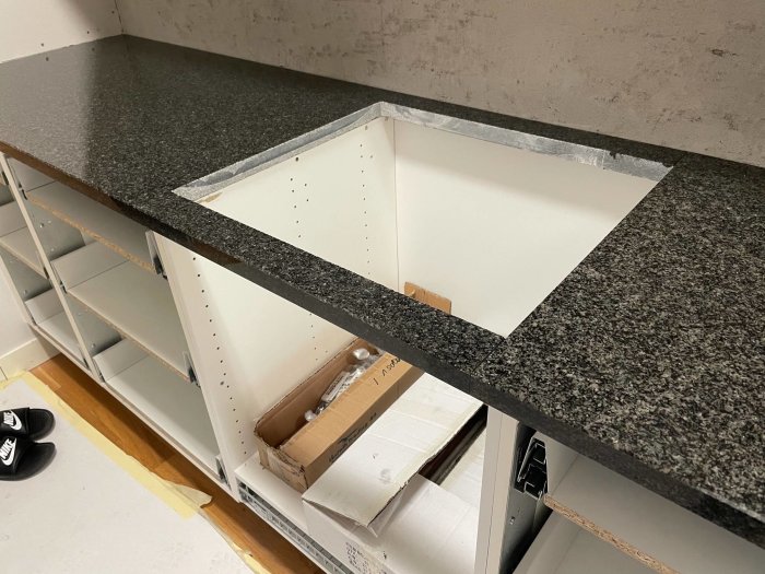 Granitbänkskiva med varierande färgnyanser installerad i kök under konstruktion.