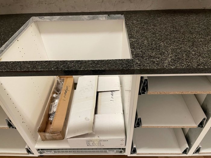 Olika färgnyanser på granitbänkskivor på köksskåp under montering.